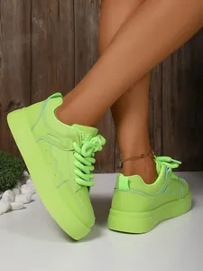 Primo piano dettagliato di sneaker platform verde neon da donna con lacci in corda.