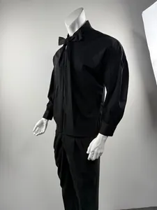 Side detail of black long-sleeve shirt featuring drop shoulder and tie neck detail