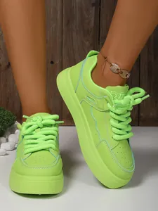 Sneaker platform verde neon con lacci spessi e dettagli blu per un look moderno e trendy.