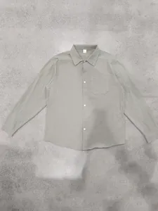 Detail view of a men's loose olive green linen long-sleeved shirt with lapel collar
