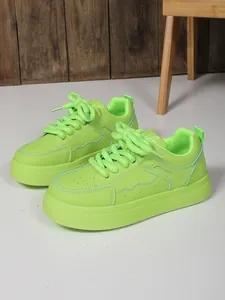Vista laterale di sneakers chunky platform verde lime con lacci spessi e cuciture a contrasto