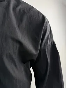 Close-up of black drop-shoulder shirt showing fabric texture and shoulder seam detail