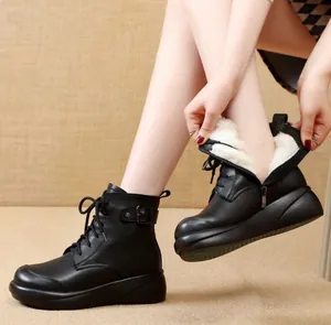 Detalle de botas Martin con plataforma negras con forro cálido de piel sintética y hebilla