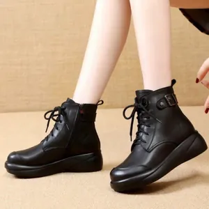 Vista detallada de botines negros con plataforma, hebilla decorativa y cordones modernos