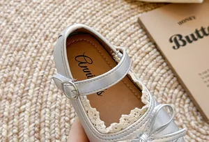 Dettaglio scarpe Mary Jane argento per bambina con bordo in pizzo e fiocco elegante