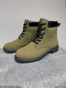 Detailed view of olive green lace-up Martin boots with matte finish and black rubber sole