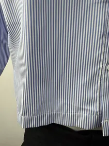 Detailed close-up showing the fine texture of a blue and white striped men's shirt.