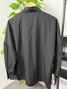 Back view detail of a minimalist black long sleeve shirt with dropped shoulders design
