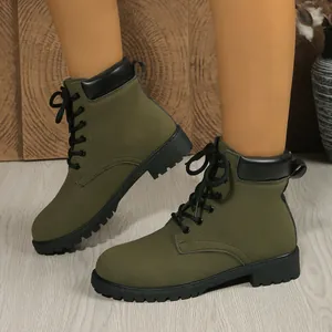 Close-up view of army green lace-up Martin boots featuring a black padded collar and lug sole