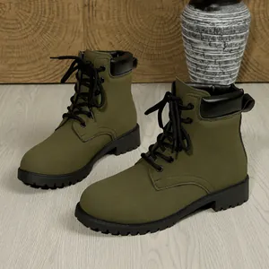 Detailed view of army green lace-up combat boots with black accents and sturdy lug soles
