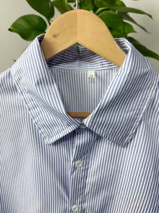 Detail view of a men's blue and white vertical striped shirt with a classic collar.