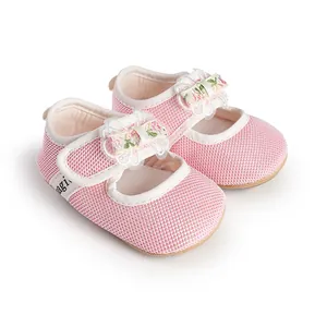 Detailed view of pink mesh baby girl princess shoes with a floral bow decoration