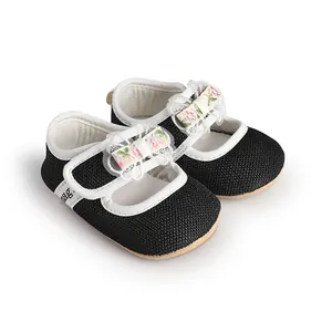 Detailed close-up showing the floral lace bow and fabric texture of baby black princess shoes