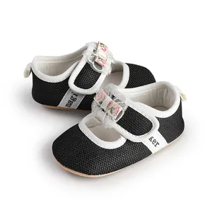 Detailed view of elegant black baby girl princess shoes with floral bow decorations.