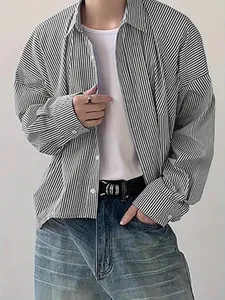 Close-up detail of a men's loose-fit vertical striped shirt in a casual layered outfit style