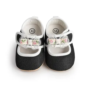 Detailed top view of black and white baby girl princess shoes with a cute floral bow