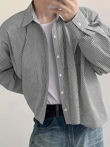Close-up of men's loose-fit long-sleeved shirt with black and white vertical stripes