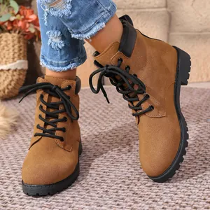 Close-up of brown suede lace-up Martin boots showing texture and durable black soles
