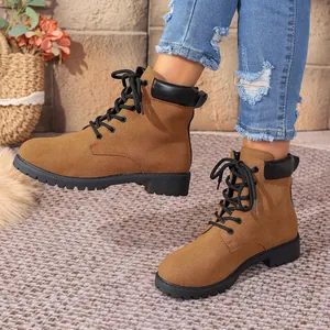 Detailed shot of brown suede lace-up Martin boots featuring a black padded collar