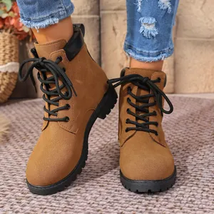 Close-up view of stylish brown lace-up Martin boots with chunky rubber soles