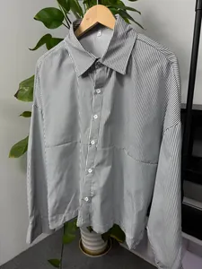 Close-up of a men's black and white vertical striped long-sleeved button-down shirt.