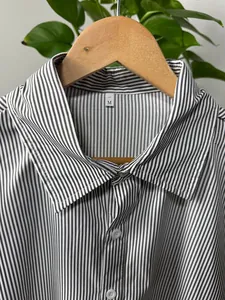 Detailed view of a men's vertical striped shirt collar featuring a size M tag on a hanger