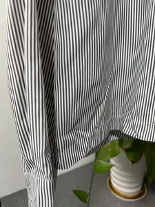 Close-up detail showing the navy and white vertical stripe pattern of a men's cotton shirt