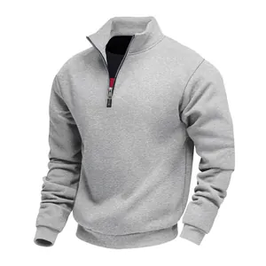 Detailed macro view of grey half-zip sweatshirt with fleece texture and rib cuffs.