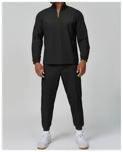Front view showing the fit of a black half-zip athletic jacket on a male model in studio.