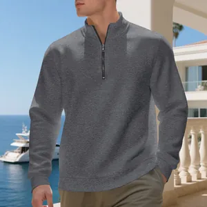 Detailed view of grey half-zip fleece pullover on male model in luxury resort setting
