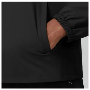 Close-up detail of side pocket and elastic cuff on men's black outdoor zip jacket