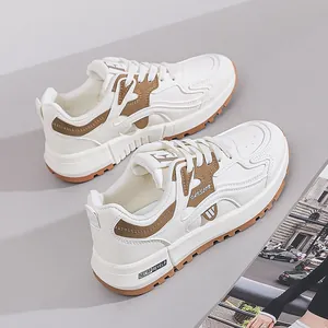 Detailansicht der weiß-braunen Damen-Chunky-Sneaker auf einem schlichten grauen Grund.