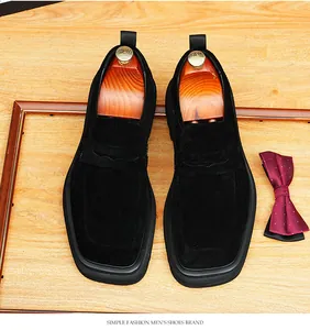 Detalle de mocasines para hombre en ante negro con suela gruesa y un diseño de punta cuadrada