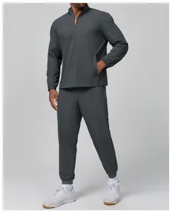 Full body view of men's charcoal grey quarter-zip sports jacket and jogger set