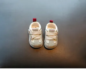 Vue de dessus de baskets souples pour bébé beiges avec pattes de talon rouges et Velcro