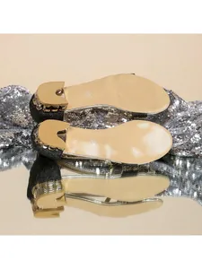Détail de la semelle dorée et du talon orné de strass sur des sandales pour femmes