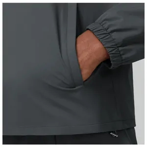 Detailed view of side pocket and elastic cuff on men's grey outdoor hiking jacket