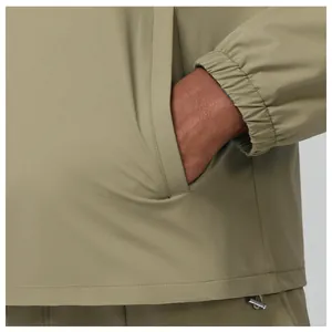 Close-up detail of lightweight olive outdoor jacket showing pocket and elastic cuff
