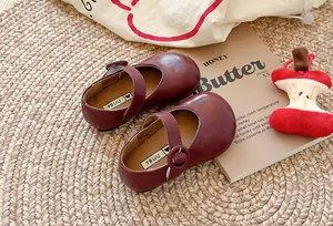 Klassische weinrote Kinder-Mary-Jane-Lederschuhe mit einem Retro-Schnallenriemen-Detail.