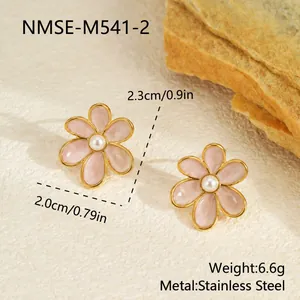Détail de boucles d'oreilles fleurs en émail rose avec perles centrales et dorure