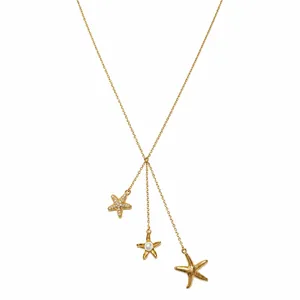 Vista detallada del collar de estrella de mar dorado con detalles de perlas y cristal