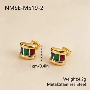 Primer plano de pendientes de acero inoxidable dorados con incrustaciones de colores