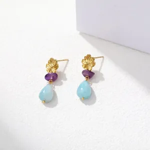Detailopname van gouden bloemoorbellen met paarse en blauwe natuursteen voor minimalistische stijl