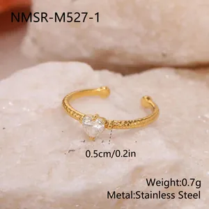 Gros plan d'une bague ouverte en acier doré avec un zircon en forme de cœur