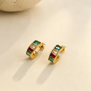 Vista detallada de pendientes de aro de acero chapado en oro con piedras de colores.
