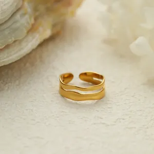 Detalle macro de un anillo abierto de acero inoxidable dorado de doble capa para mujer
