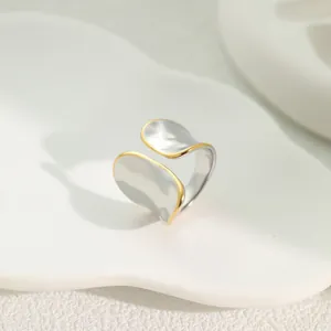 Macro view of gold and silver two-tone stainless steel open leaf wrap ring detail