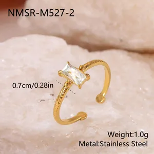 Vue détaillée d'une bague en acier doré avec une pierre rectangulaire et un anneau torsadé.
