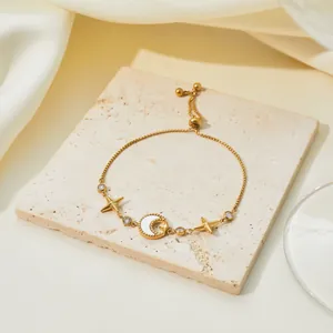 Close-up of gold-plated celestial bracelet with star, moon motifs and shell inlay