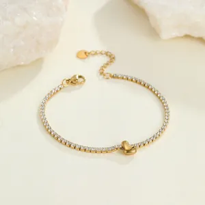 Elegantes goldenes Edelstahl-Tennisarmband mit Herzanhänger und weißen Steinen Detail